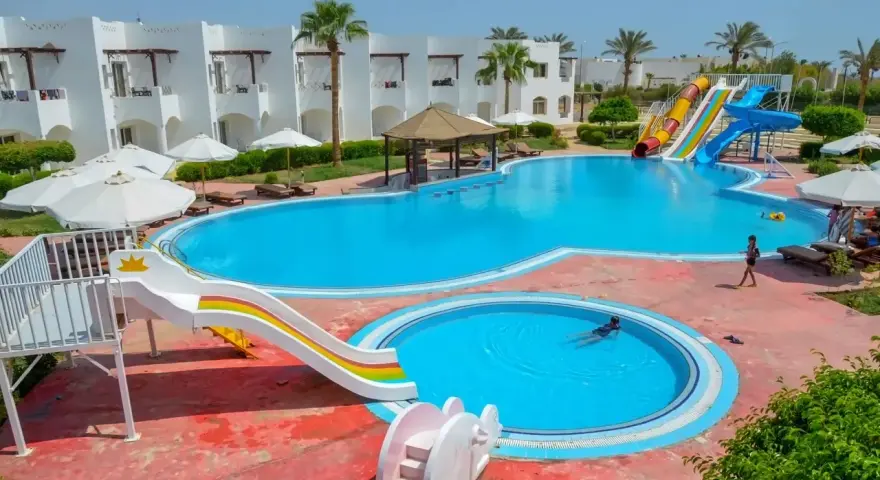 Egipt last minute all inclusive najtaniej: basen z wodnymi zjeżdżalniami i palmami, idealny na wakacje.