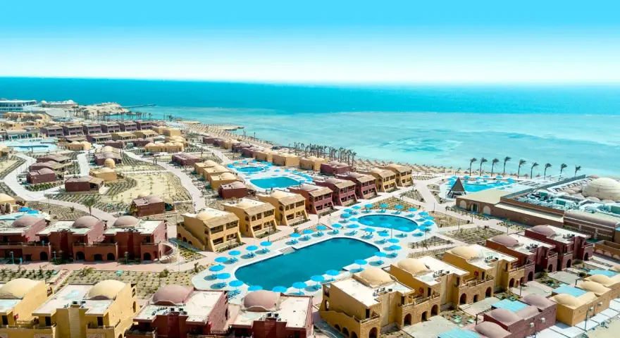 Widok z lotu ptaka na kompleks hotelowy Pickalbatros Marsa Alam z basenami i budynkami w stylu orientalnym, w tle turkusowe Morze Czerwone.