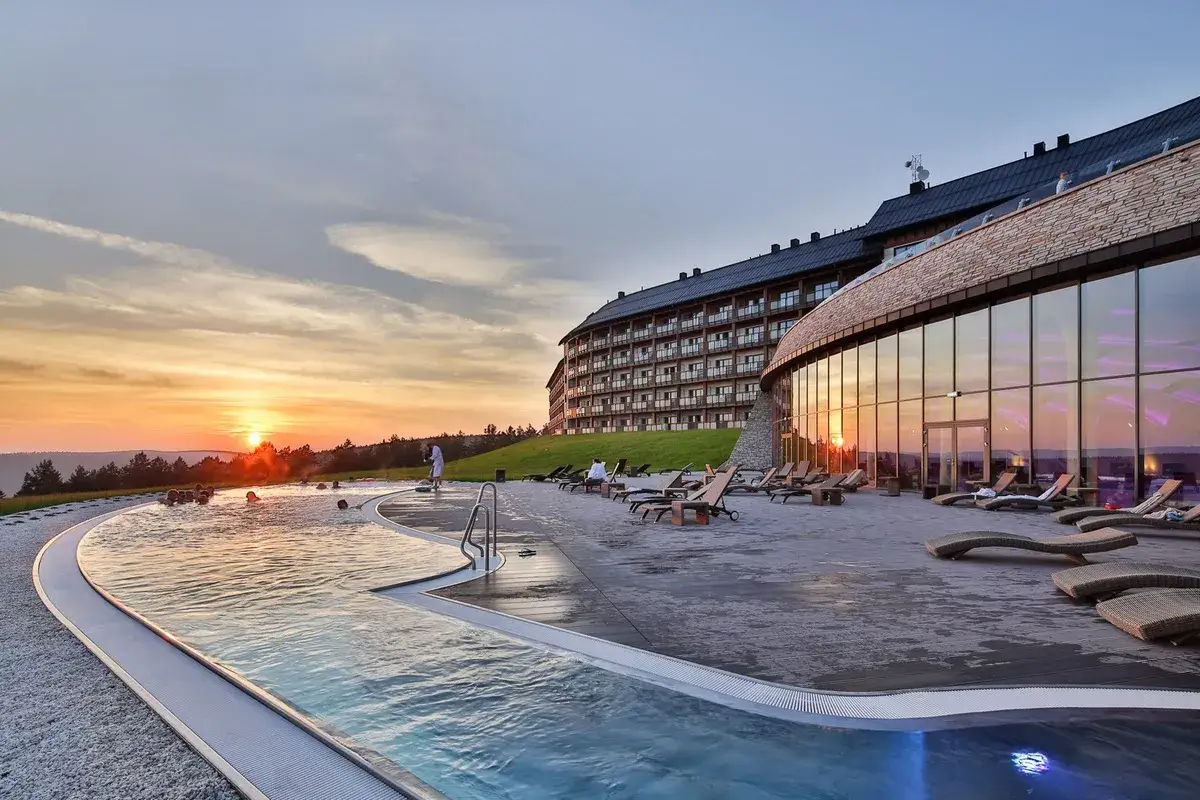 Zachód słońca nad basenem zewnętrznym hotelu Arłamów. Sprawdź hotel arłamów ceny i zarezerwuj pobyt.