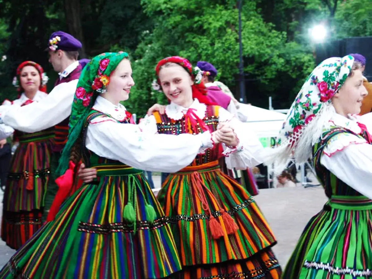 Tancerze w barwnych strojach ludowych, z kolorowymi chustami na głowach, tańczą radośnie. Dziwne ciekawostki o tradycjach ludowych mogą być fascynujące!