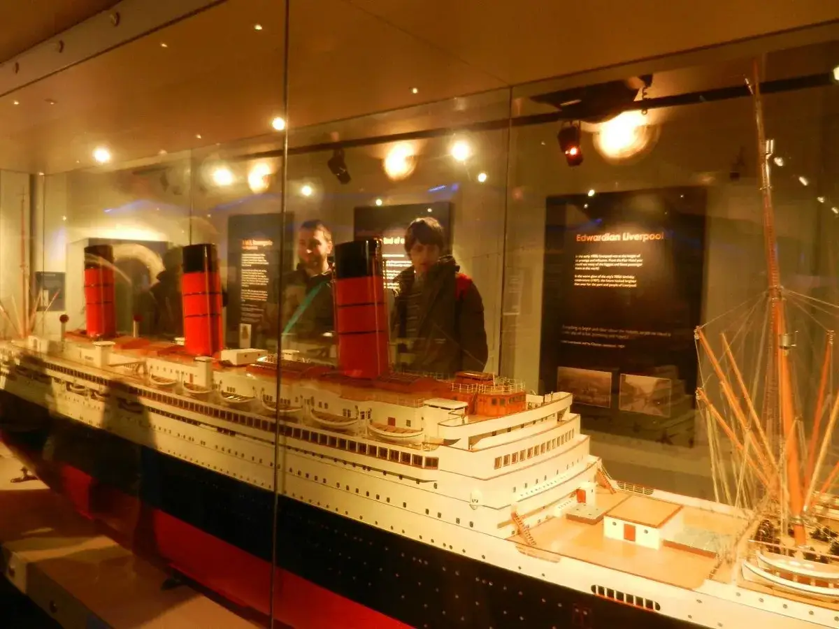 Model statku przypominającego RMS Titanic, z dwoma osobami w tle. Wystawa opowiada o katastrofie Titanica.