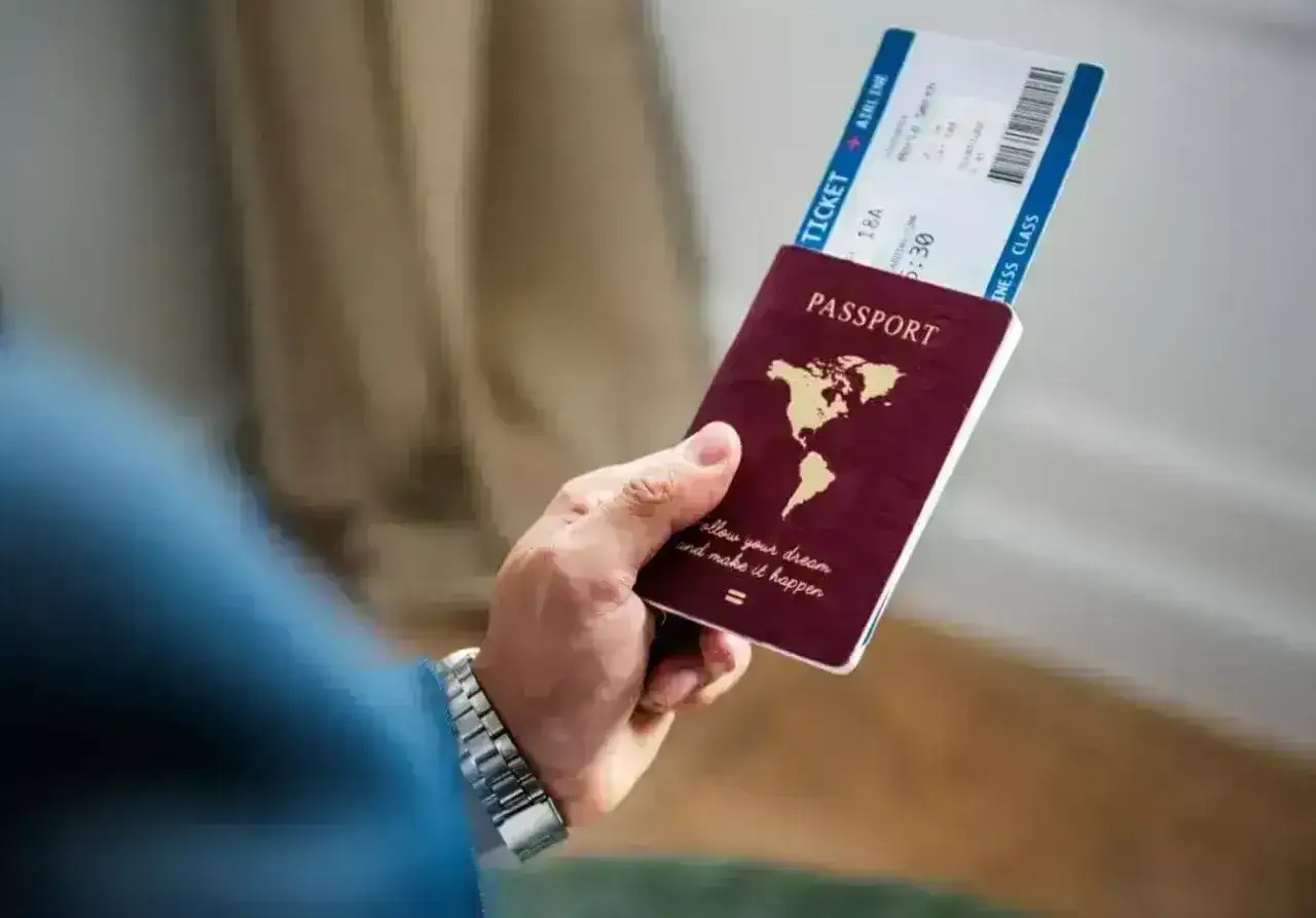 Dłoń trzyma paszport i bilet lotniczy. Planujesz podróż i zastanawiasz się, czy Cypr jest w Schengen?
