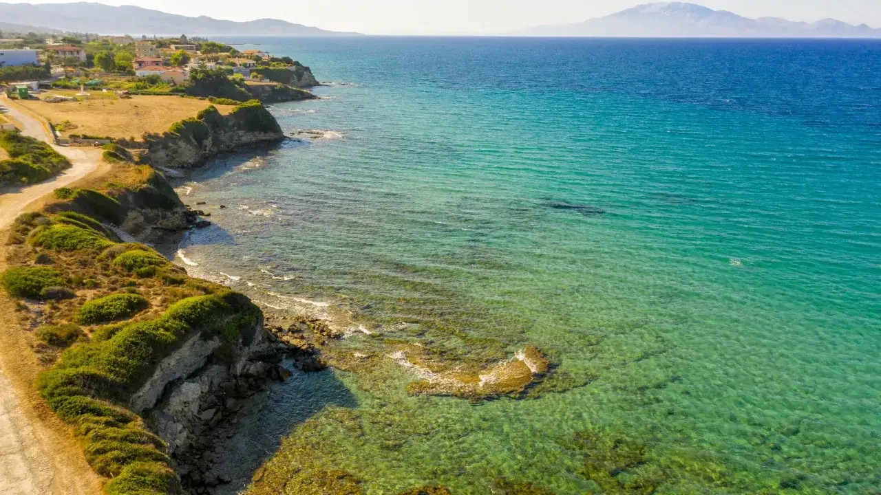 Malownicze wybrzeże Tragaki na Zakynthos, z klifami, zielenią i krystalicznie czystą wodą.
