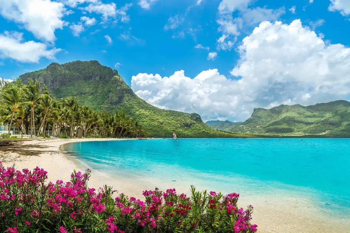 Rajska plaża na Mauritiusie. Zielone góry, palmy i turkusowa woda. Idealne miejsce, by zobaczyć, co Mauritius ma do zaoferowania.