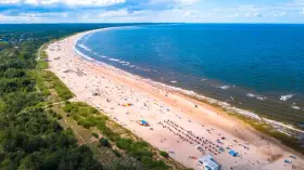 Szeroka, piaszczysta plaża z tłumem turystów, zielony las i błękitne morze – to jedne z najpiękniejszych plaż w Polsce.