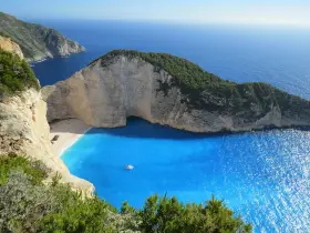 Grecja gdzie na wakacje? Zatoka Wraku na Zakynthos, z turkusową wodą i klifami, idealne miejsce na niezapomniany urlop.